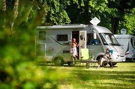 Zwei Frauen vor einem Campingwagen auf dem Wohnmobilstellplatz