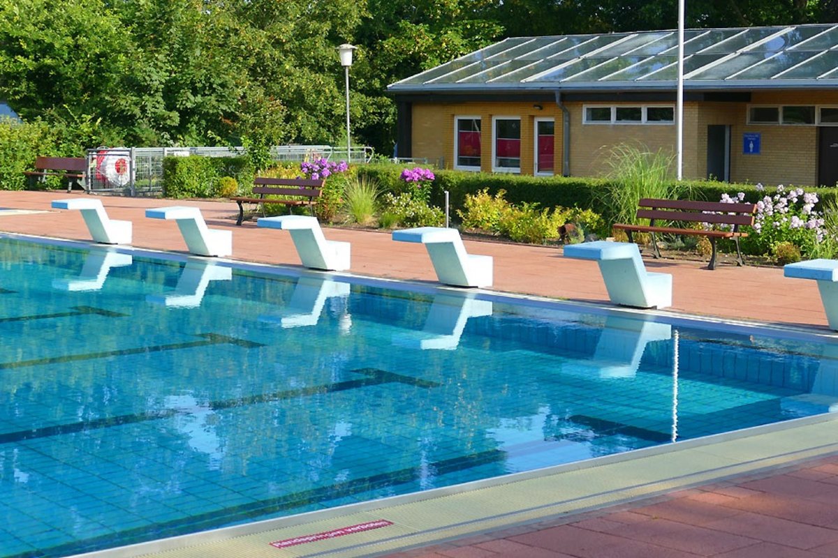 Schwimmbecken mit Startblöcken und Blumenbeet