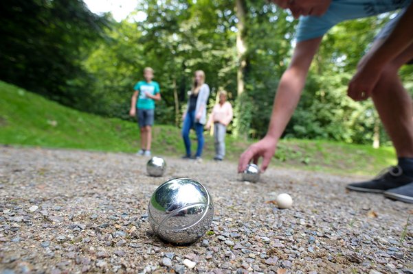 Boulekugeln und vier Personen
